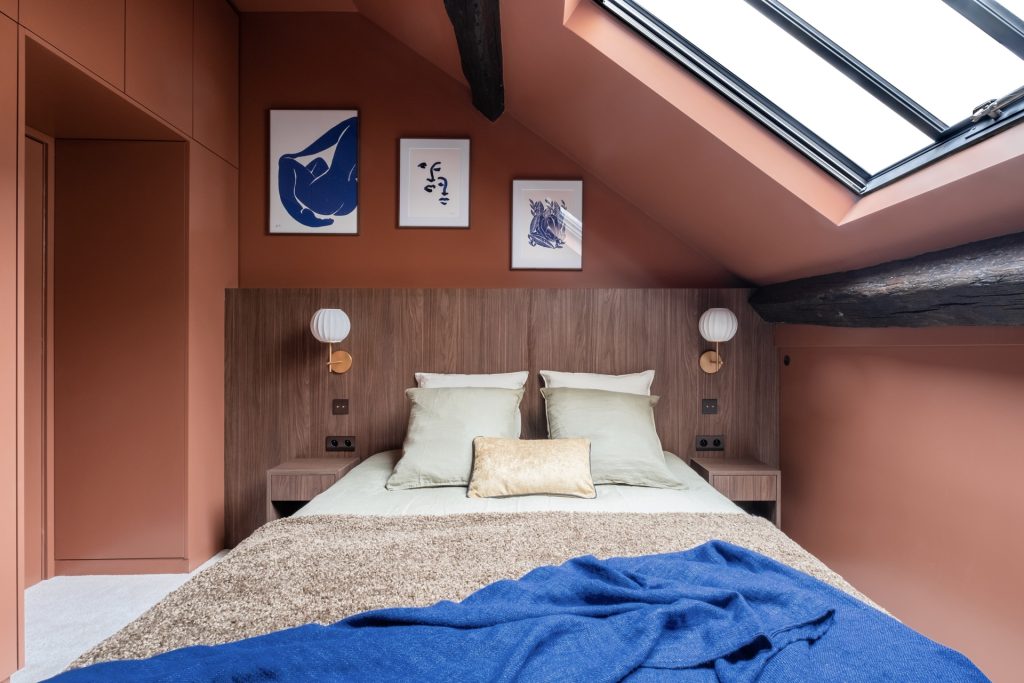 Photo d'une tête de lit dans une chambre mansardé.